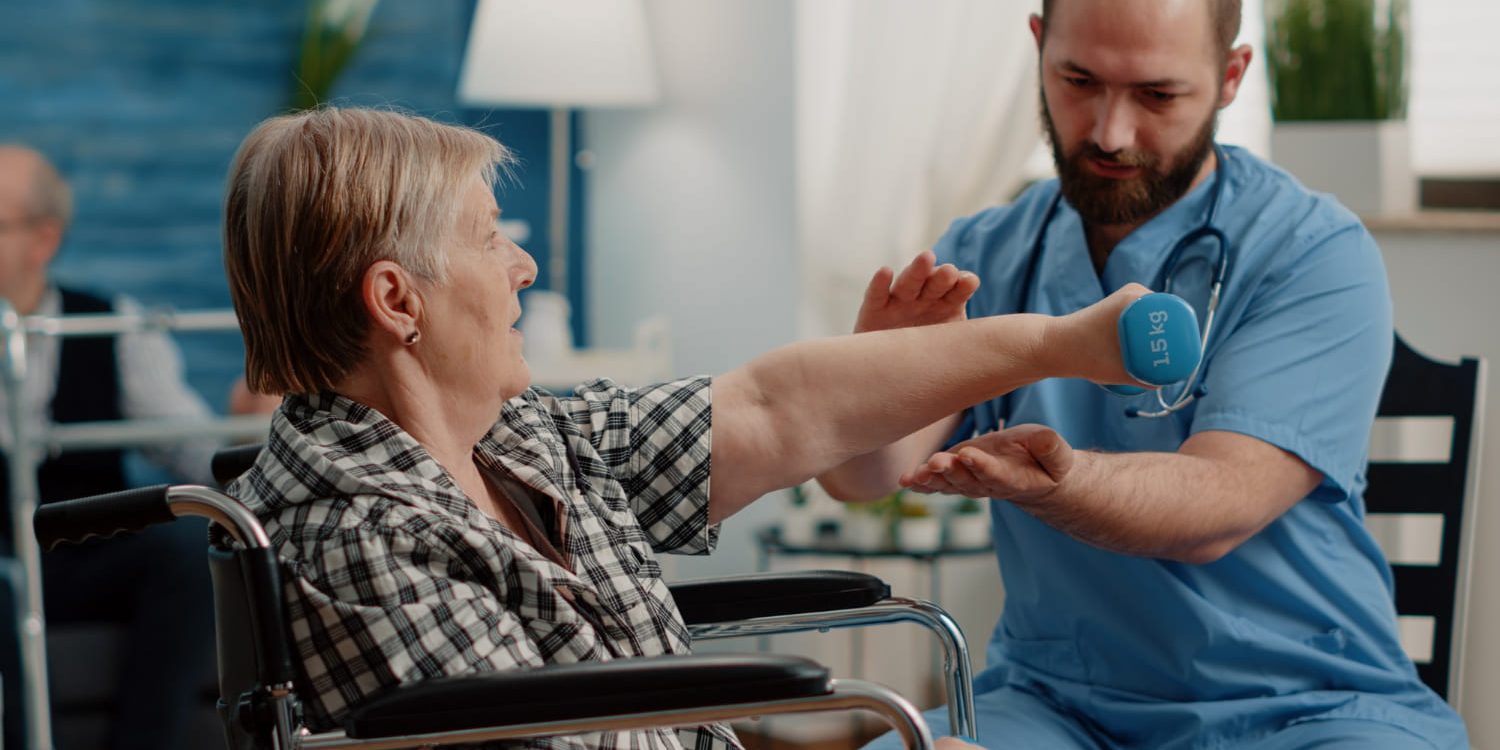 Armtraining met gewichten revalidatie Fysiotherapeut ondersteunt armtraining met gewicht bij herstel en gewichtsverlies