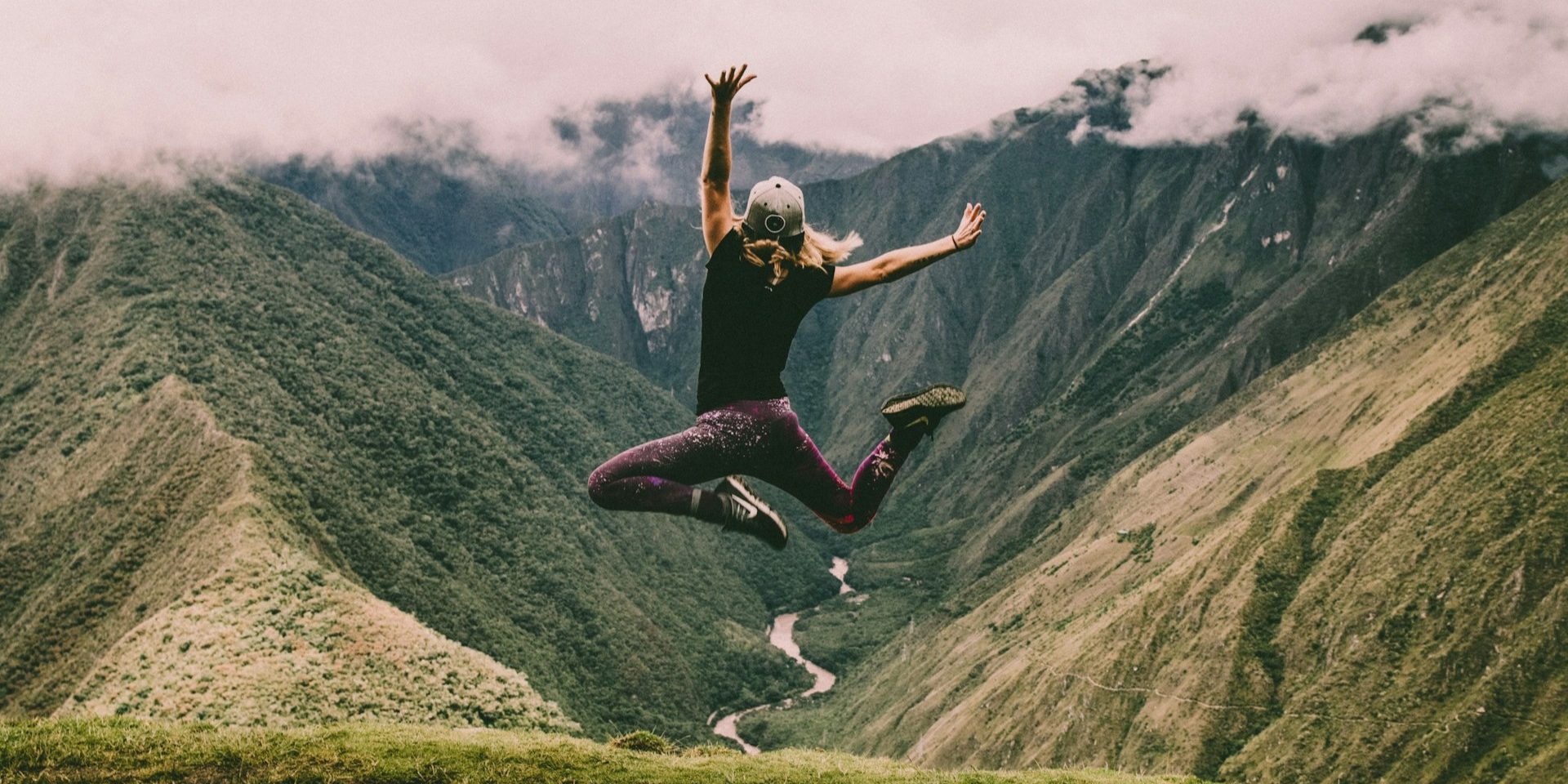 Persoon springt op bergtop in natuur en ervaart energie en vrijheid na zuurstoftraining