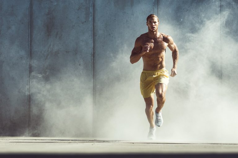 Hardloper in mistige omgeving toont intens zweten tijdens inspanning en fysieke belasting tijdens training
